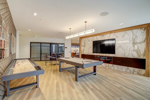 a game room with two ping pong tables and a television